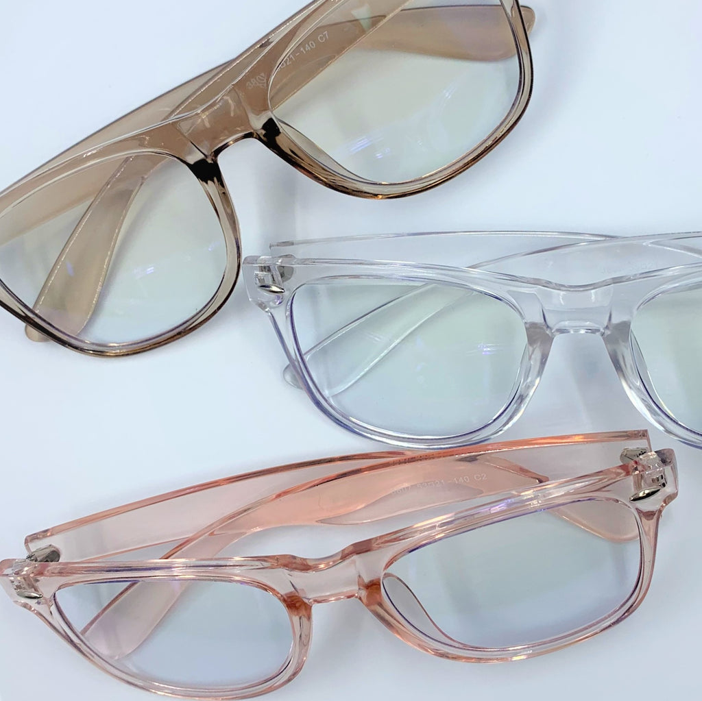 Blue light filtering glasses, shown in clear, champagne and pink pastel translucent frames. 